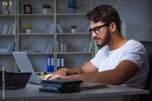 Valokuva Young man staying late in office to do overtime work