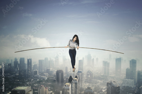 Beautiful businesswoman balancing on a rope photo