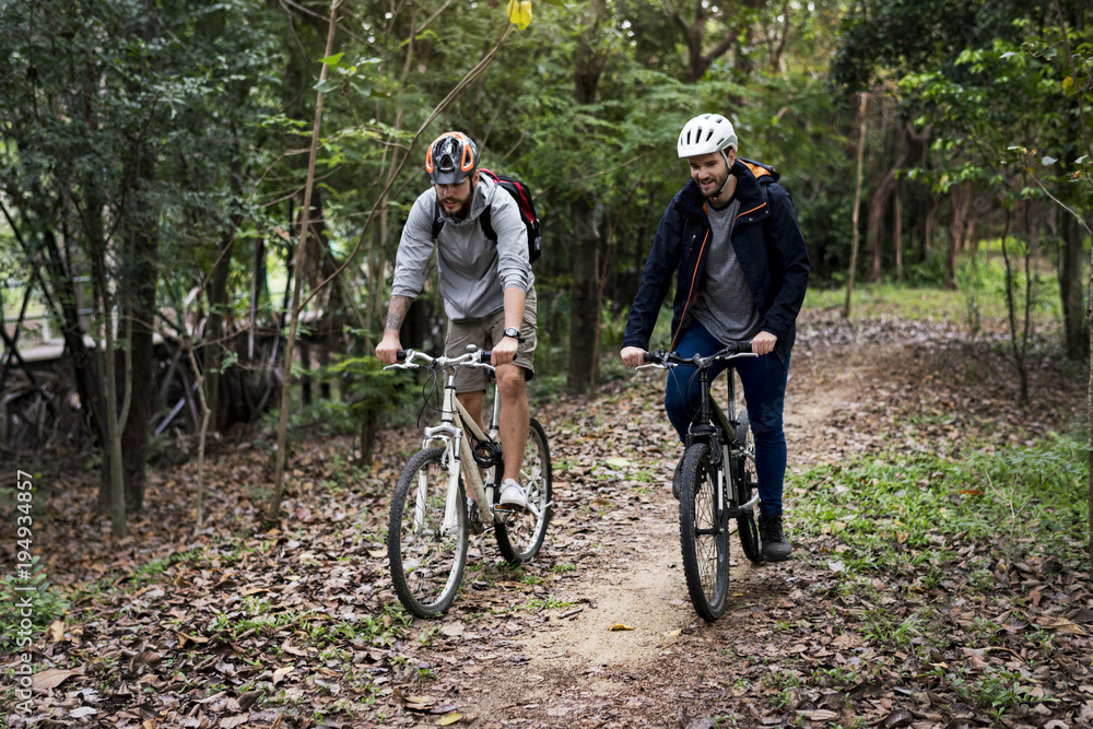 Fototapeta premium Group of friends ride mountain bike in the forest together