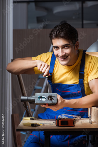 Worker working in repair workshop in woodworking concept