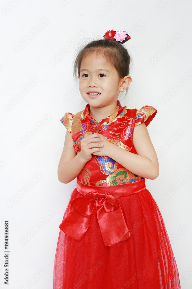Happy little Asian child girl wearing red cheongsam with greeting gesture celebration for Chinese New Year isolated on white background. Happy little Asian child girl wearing red cheongsam with greeting gesture celebration for Chinese New Year isolated on white background.