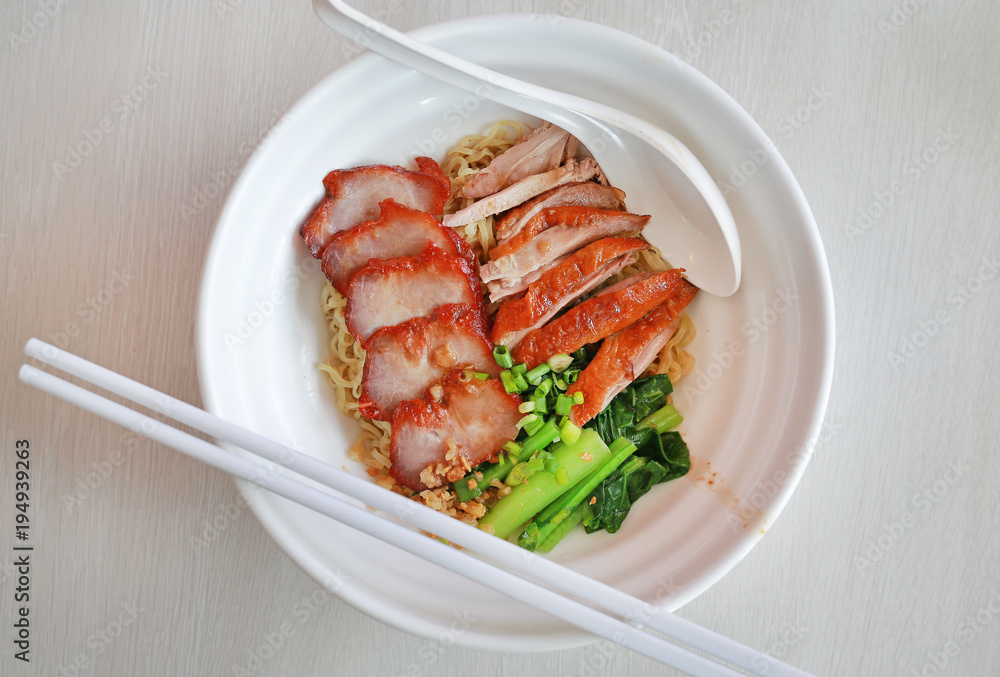Top view Egg noodle with roasted duck and pork, Chinese food.
Top view Egg noodle with roasted duck and pork, Chinese food.