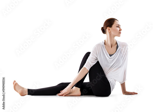 Young woman sitting on the floor and stretching.