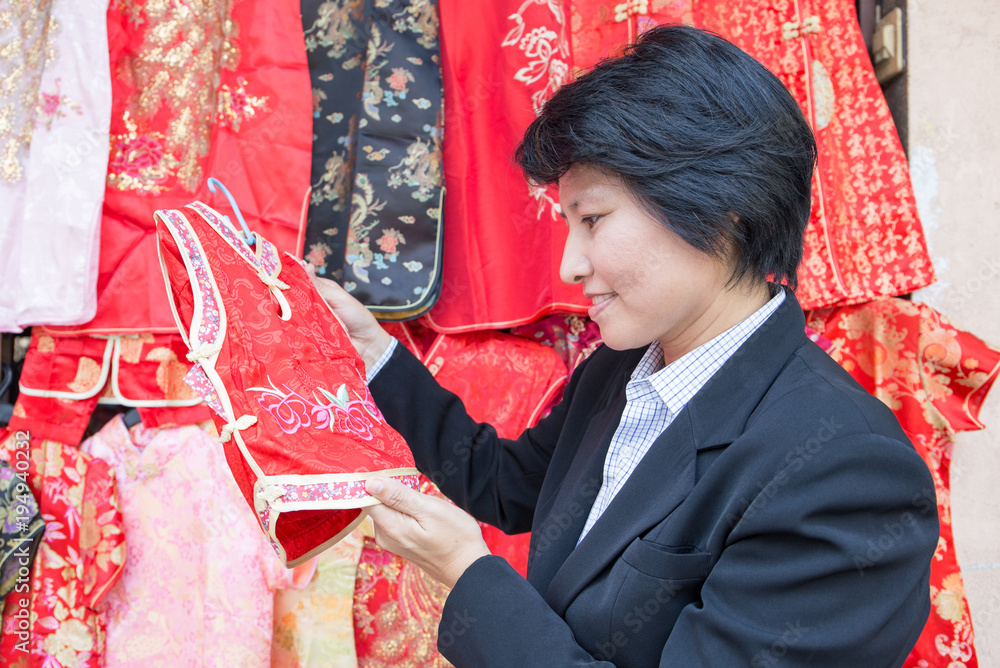 Φωτογραφία Asian business woman look at small size of qipao dress at Yaowarat, Bangkok, Tha