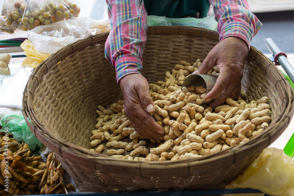 Φωτογραφία Local seller wear plaid shirt hold boiled peanut in a can, Yaowarat, Bangkok, Th