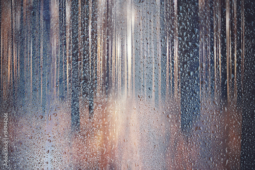 glass wet autumn background, rain in the park glass wet surface with reflection, rain drops on the drenched window glass, background window in the autumn park, autumnal rainy landscape blurred © kichigin19