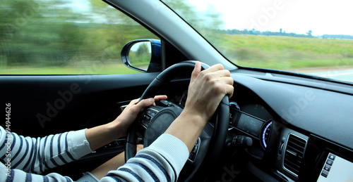 Foto Wrong position of man’s hands on the steering wheel inside fast moving vehicle