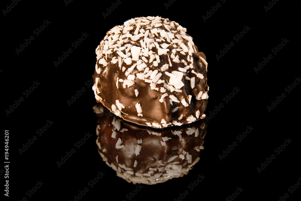 Chocolate cake on a black mirror surface sprinkled with coconut chips Chocolate cake on a black mirror surface sprinkled with coconut chips