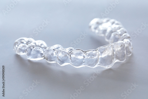 Niewidzialne szelki lub niewidoczny wyrównywacz ortodontyczny.