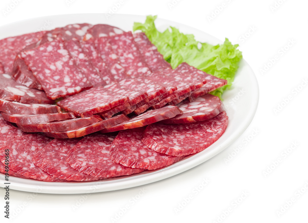 Sliced different salami and smoked sausage on dish closeup