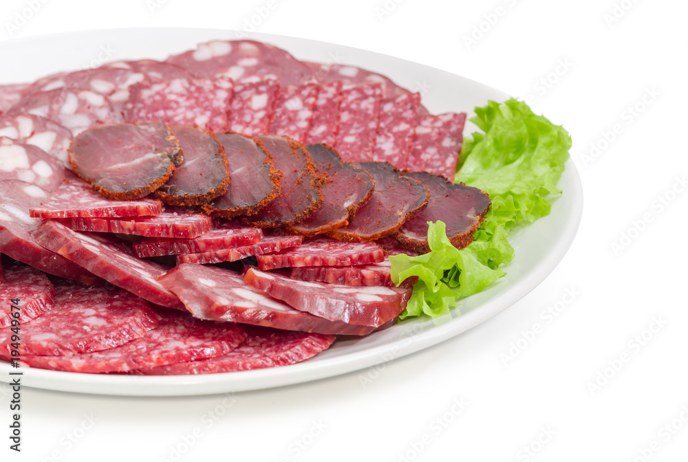 Sliced different salami and other meat products on dish closeup