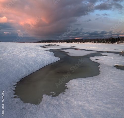 sunset on the banks of a frozen river © smolskyevgeny