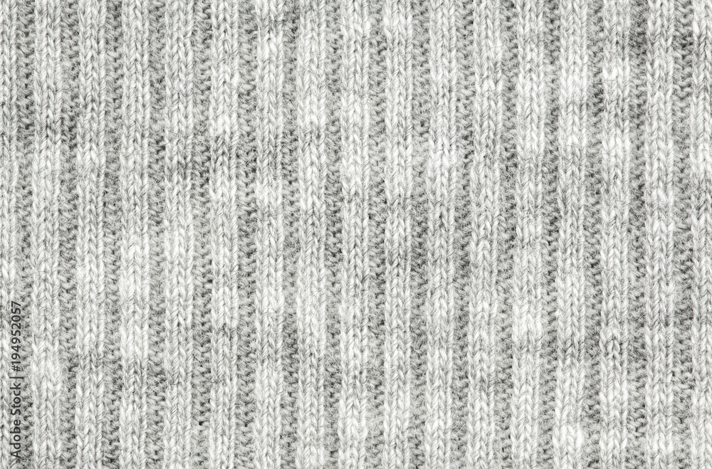 Real white-grey knitted fabric made of synthetic fibres textured background. Real white-grey knitted fabric made of synthetic fibres textured background.