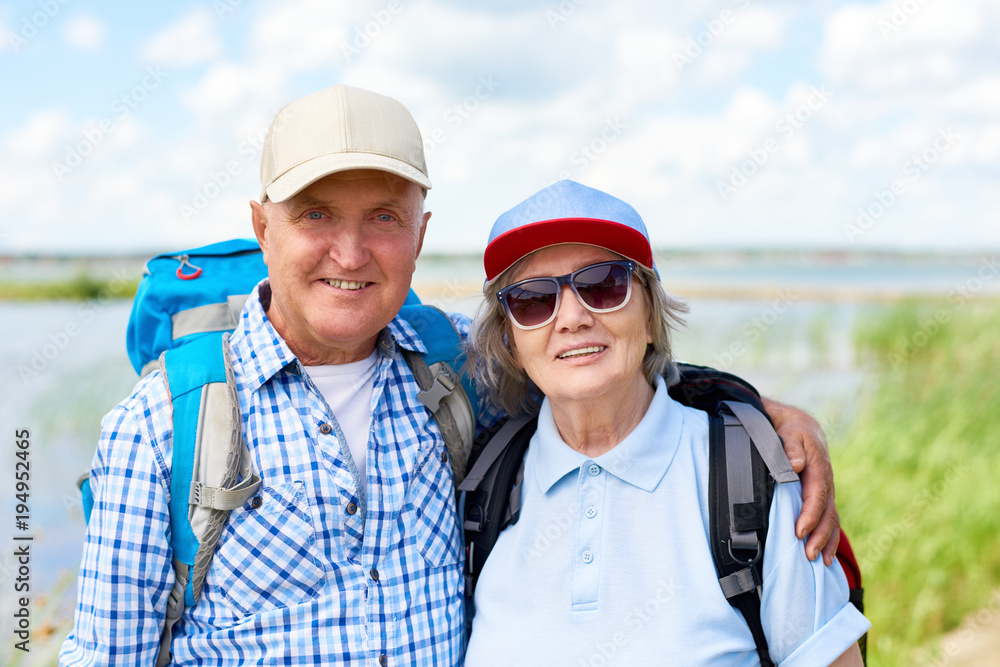 Portrait of active senior couple travelling on hiking trip, smiling looking at camera enjoying vacation Portrait of active senior couple travelling on hiking trip, smiling looking at camera enjoying vacation