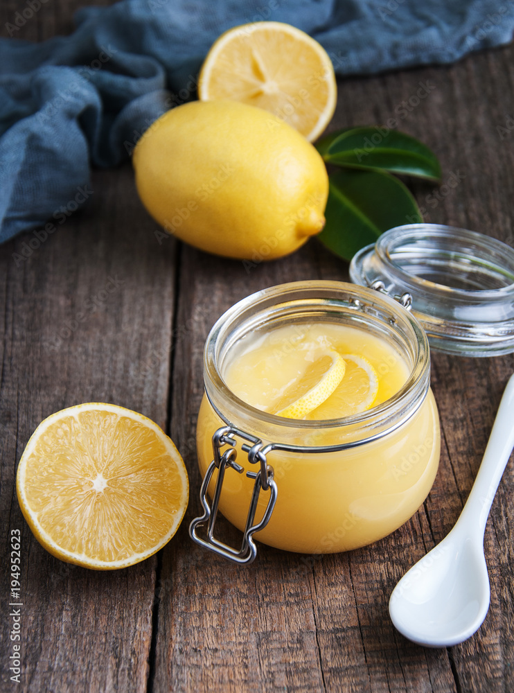 Lemon curd in glass jar with fresh lemons Lemon curd in glass jar with fresh lemons