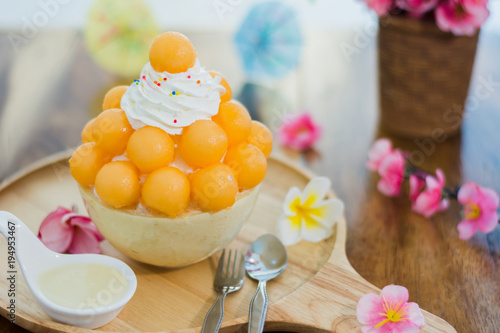 Closeup cantaloupe Bingsu on tray, Bingsu or Bingsoo, Korean shaved ice dessert with sweet toppings and fruit and varieties with ingredients,  popular dessert. photo