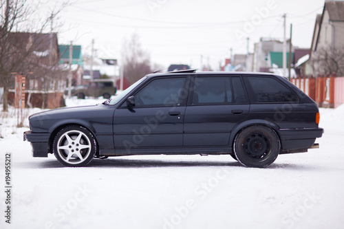 Old, black, German family car side view in winter