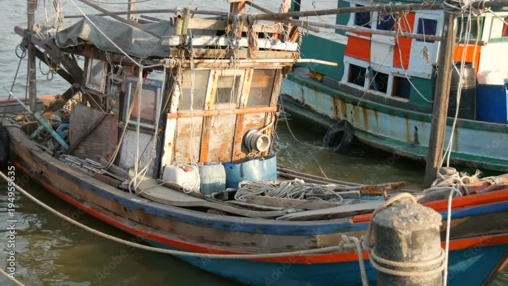 Old wooden half-ruined and wrecked ship is moored on a fishing dock Old wooden half-ruined and wrecked ship is moored on a fishing dock