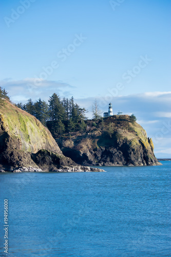 bright lighthouse in pacific norhtwest overlooking pacific ocean photo