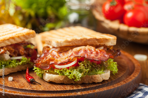Toasted sandwich with bacon, tomato, cucumber and lettuce. photo