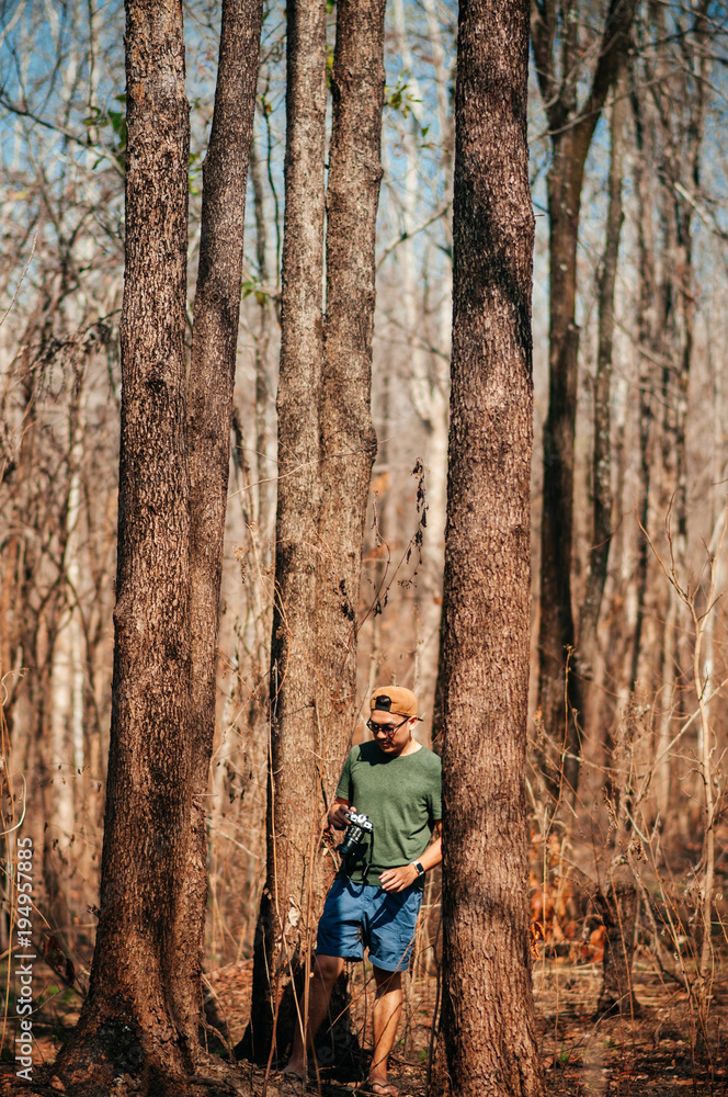 Young asian male photographer with casual cloth in forest travel in nature concept. Thailand Young asian male photographer with casual cloth in forest travel in nature concept. Thailand