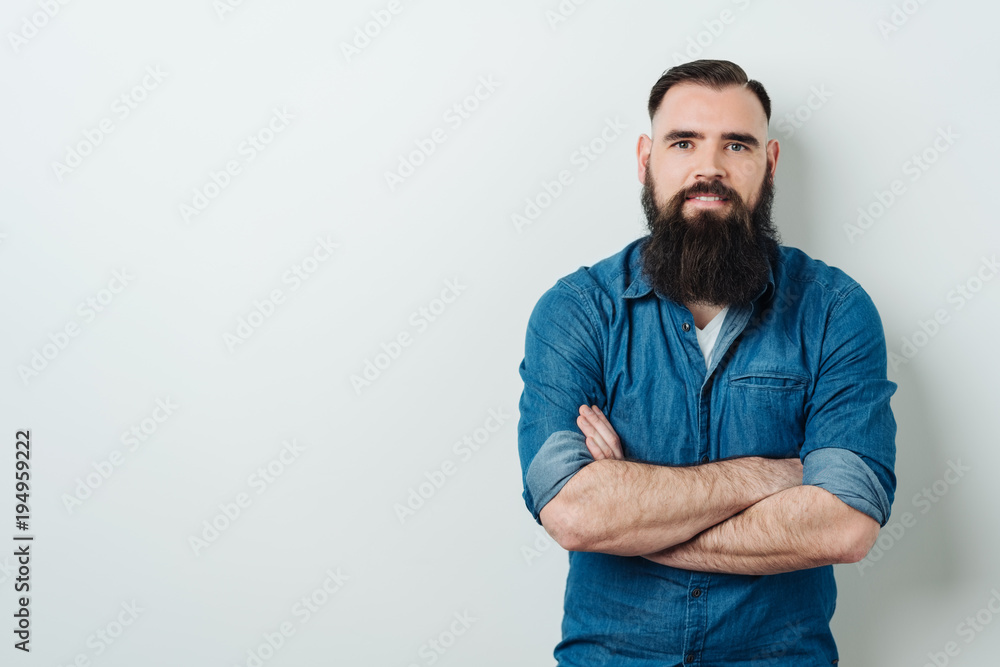 Bearded man staring at the camera with a smile - obrazy, fototapety, plakaty 