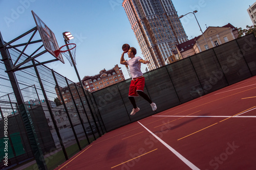 Εκτύπωση καμβά It is time to win! Full length side view of young man in sportswear playing bask