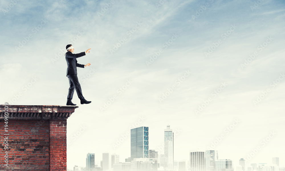 Danger and risk concept with businessman making step from edge Danger and risk concept with businessman making step from edge
