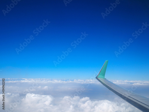 Cloudy sky with wing of airplane.