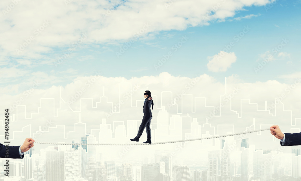 Business concept of risk support and assistance with man balancing on rope Business concept of risk support and assistance with man balancing on rope