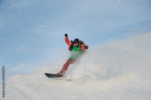 Young man having fun sliding on the snowboard