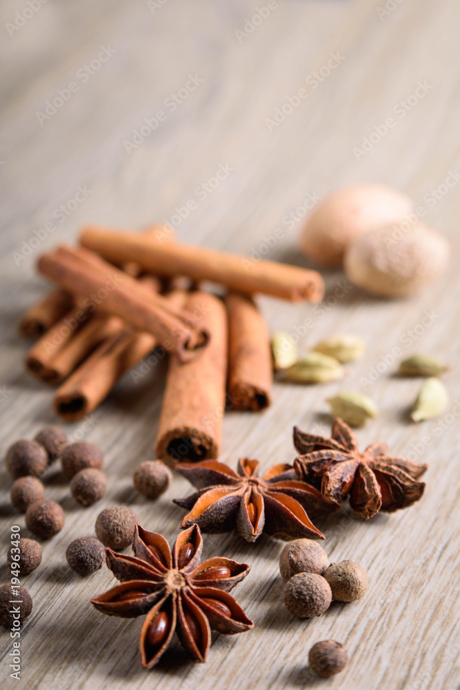Various Spices background. Cinnamon sticks and anise stars close-up on wood background Various Spices background. Cinnamon sticks and anise stars close-up on wood background