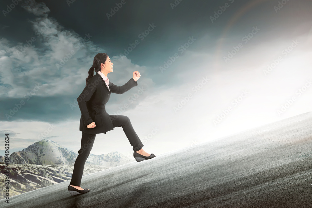 Pretty asian business woman running to climb a hill Pretty asian business woman running to climb a hill