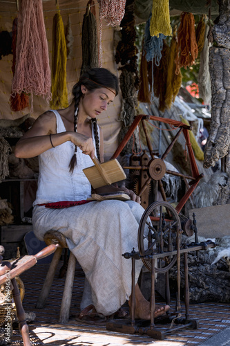 Portrait of a young woman, carding wool at a street market