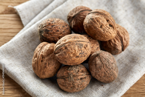 A stack of walnuts piled together and on rustic wooden background, shallow depth of field, selective focus
