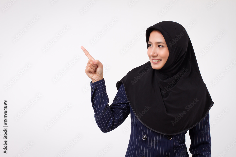 confident happy smiling successful muslim business woman pointing up; studio portrait of islamic business woman pointing finger; asian businesswoman, female business person points up to space confident happy smiling successful muslim business woman pointing up; studio portrait of islamic business woman pointing finger; asian businesswoman, female business person points up to space