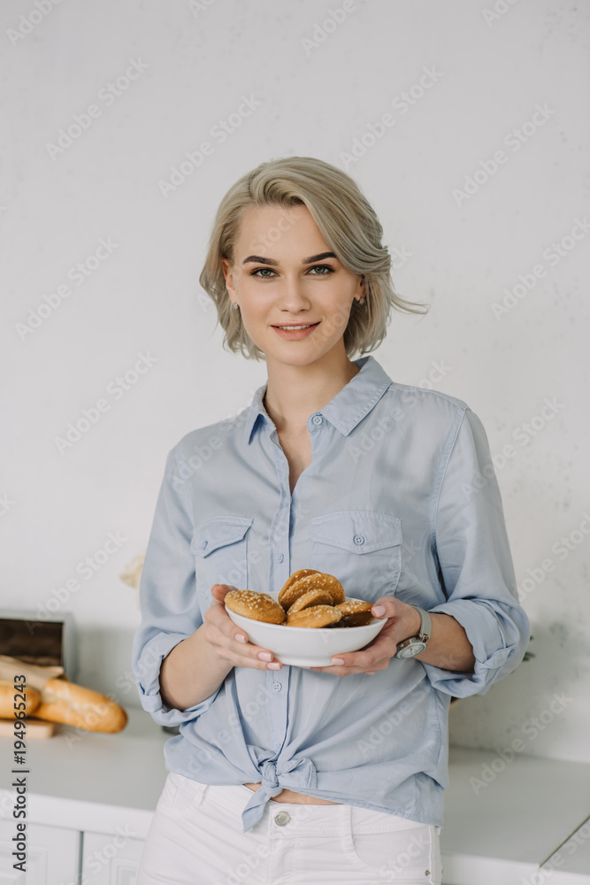 beautiful girl holding bowl of oat cookies at home beautiful girl holding bowl of oat cookies at home
