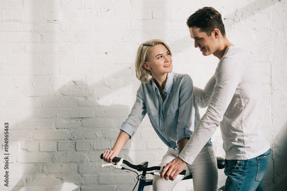 boyfriend hugging girlfriend sitting on bicycle at home boyfriend hugging girlfriend sitting on bicycle at home