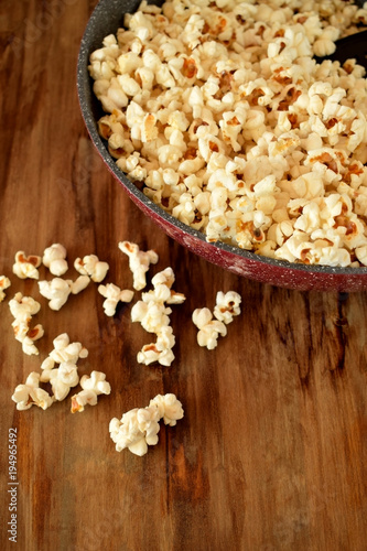 Popcorn in a frying pan on a wooden table