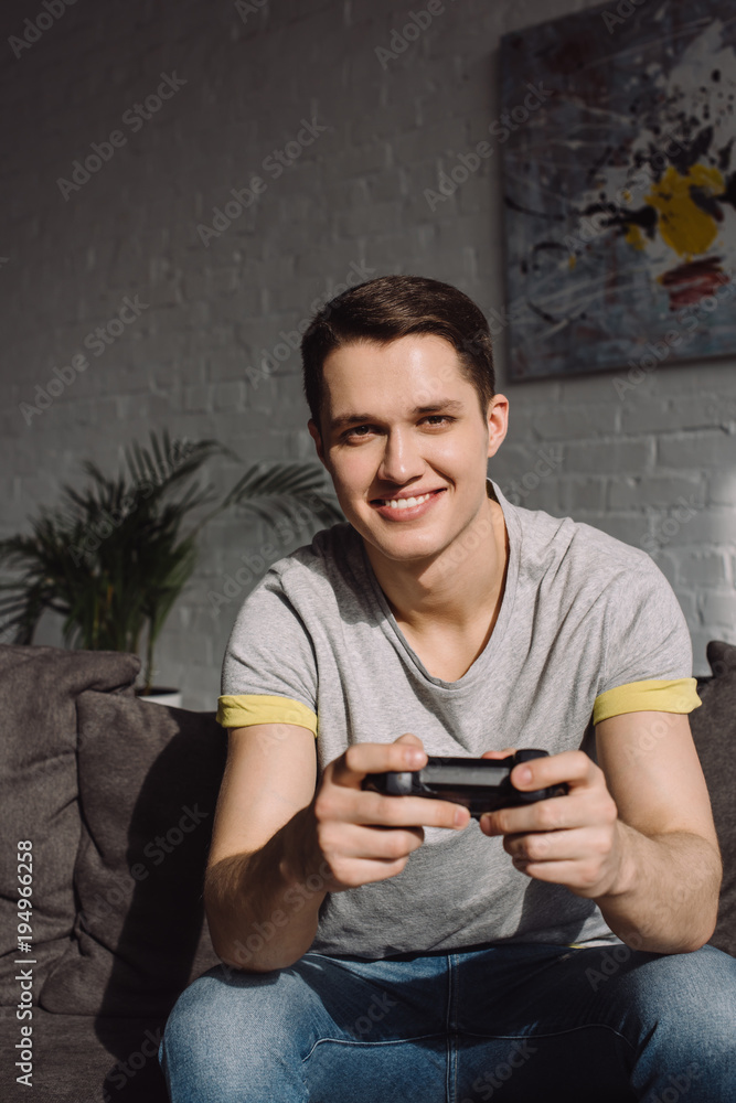 handsome man playing video game at home and looking at camera handsome man playing video game at home and looking at camera