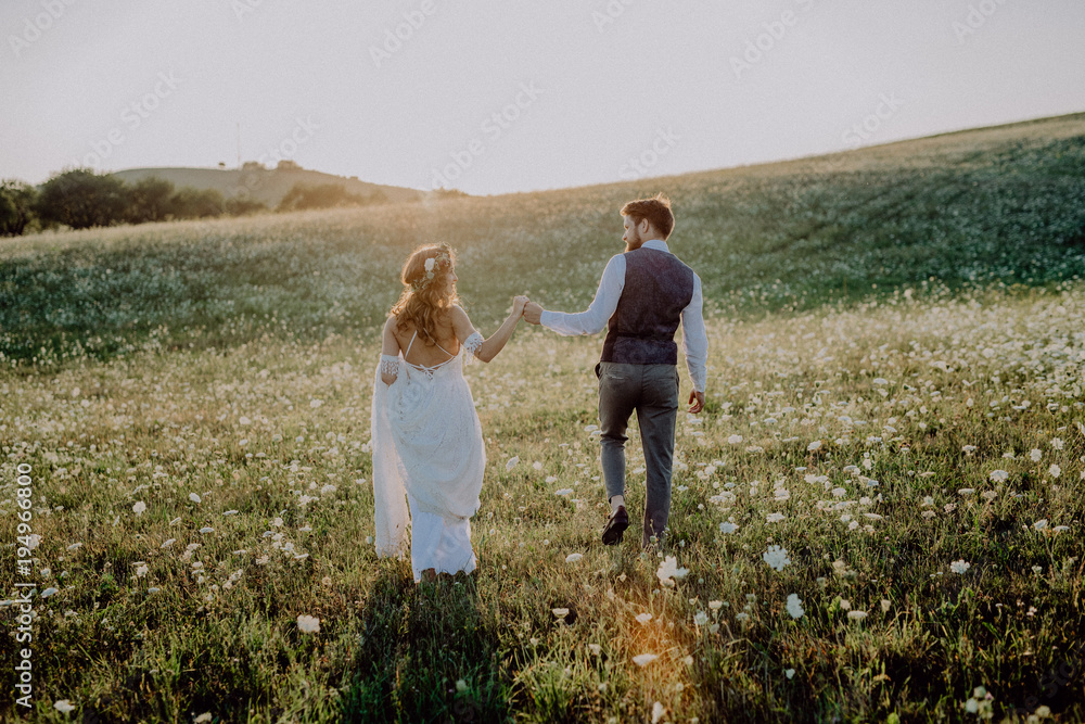 Beautiful bride and groom at sunset in green nature.