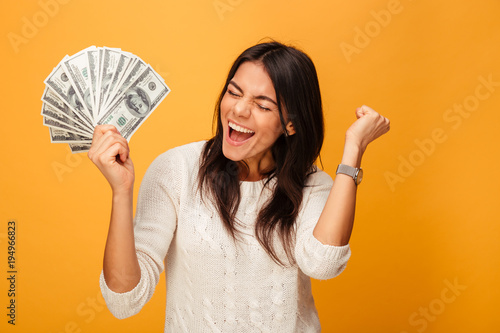 Portrait of a cheerful young woman holding money