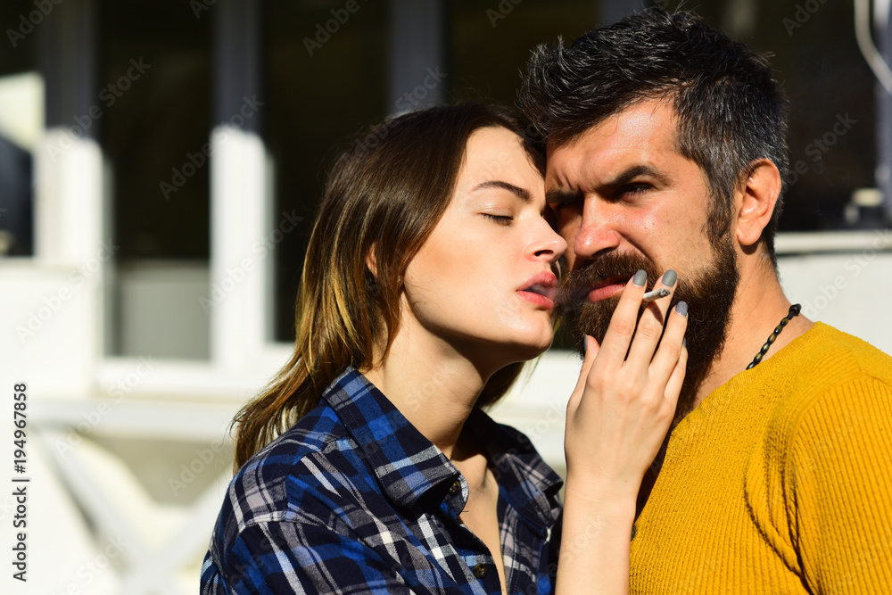 Sensual couple puffing smoke into face. Woman with eyes closed Sensual couple puffing smoke into face. Woman with eyes closed