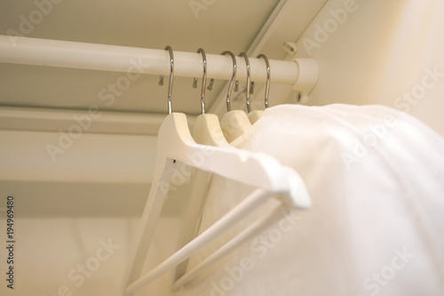 row of men and women shirts on the hanger, hanging in the wardrobe