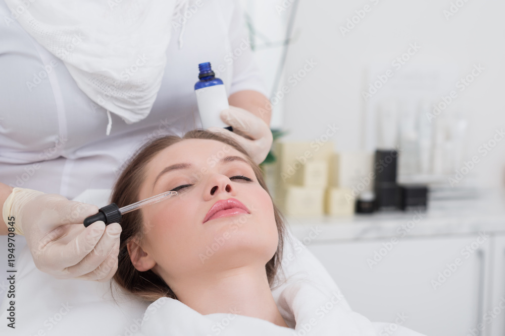 partial view of young woman receiving facial treatment made by cosmetologist in salon partial view of young woman receiving facial treatment made by cosmetologist in salon