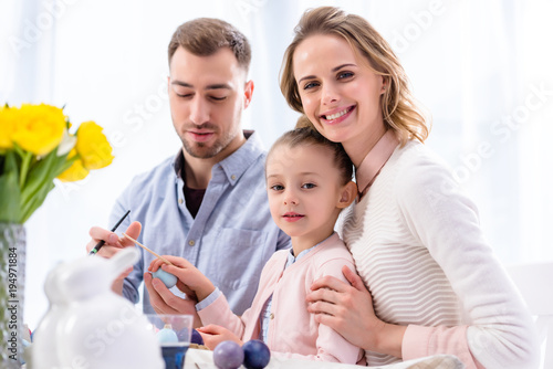 Parents and daughter celebrating with Easter eggs