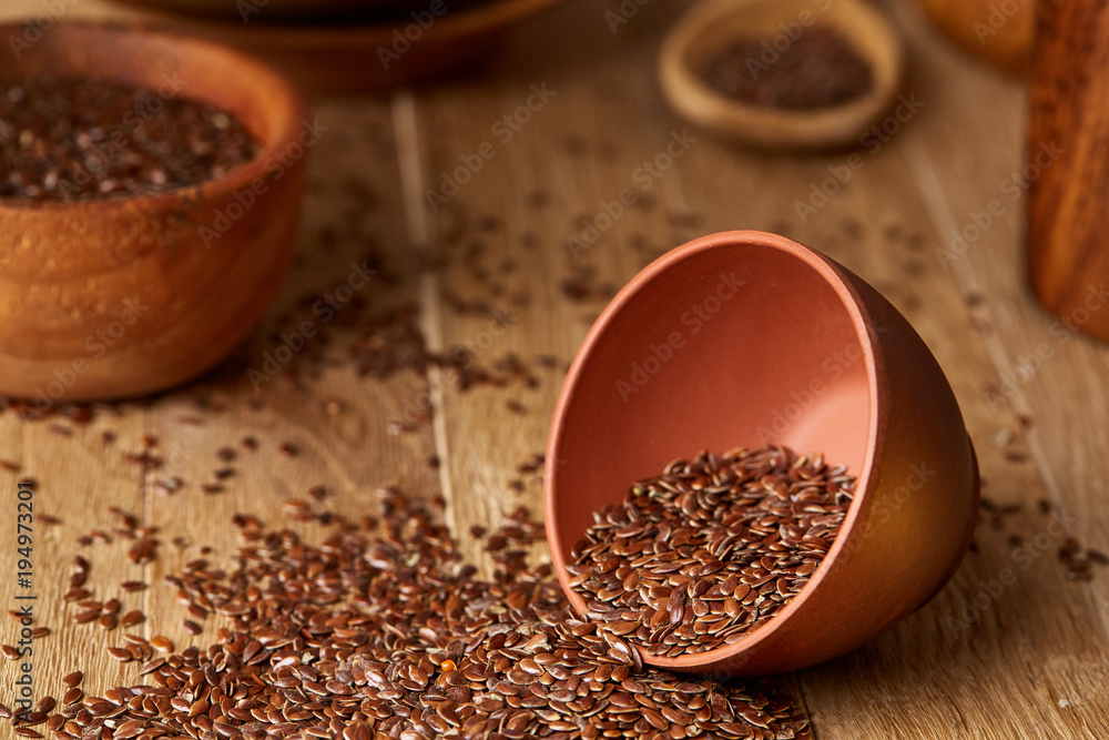 An overturned ceramic bowl with linseeds on a rustic background, close-up, shallow depth of field, selective focus An overturned ceramic bowl with linseeds on a rustic background, close-up, shallow depth of field, selective focus