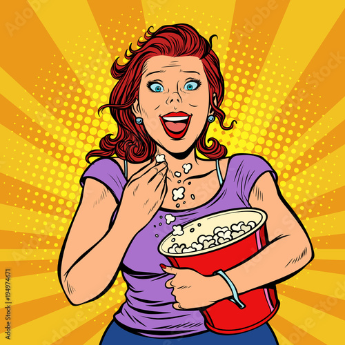 Fototapeta Woman watching a movie, smiling and eating popcorn