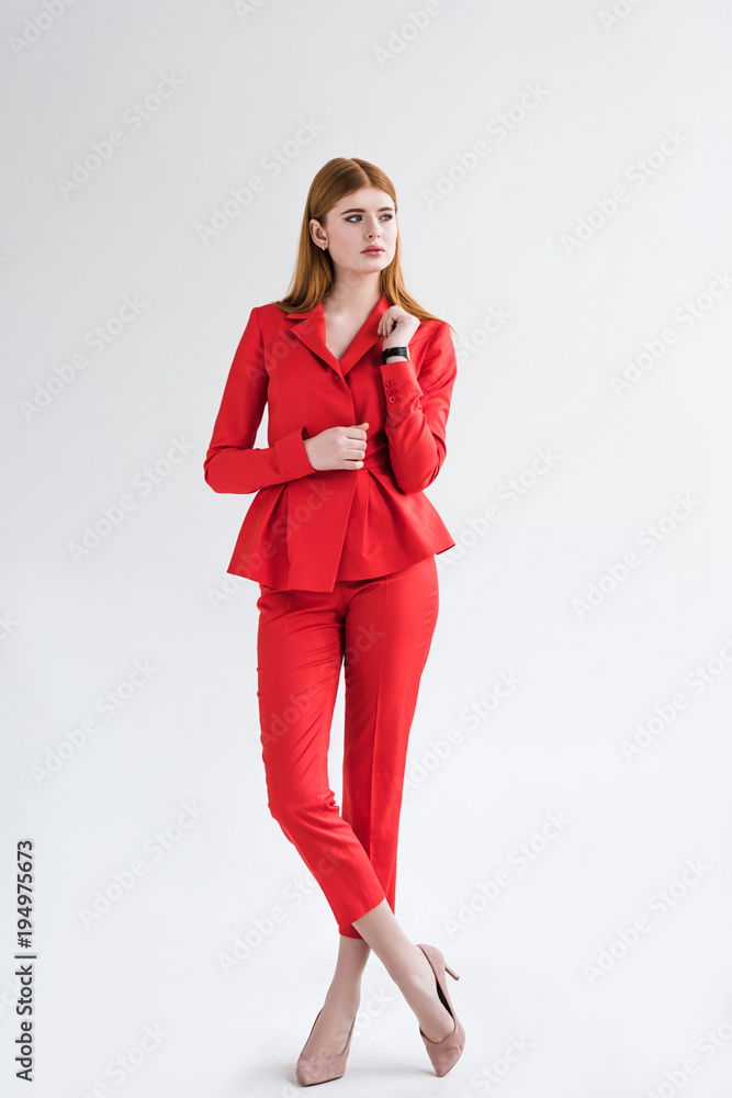Stylish young female dressed with wristwatch dressed in suit isolated on grey Stylish young female dressed with wristwatch dressed in suit isolated on grey
