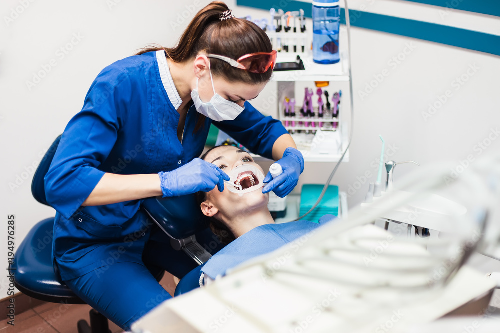 Fototapeta premium Dentist holding tooth whitening procedure